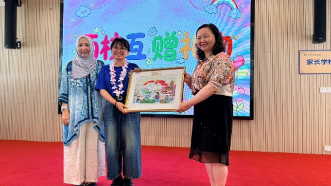 Student presenting a commemorative gift during a cultural exchange event.