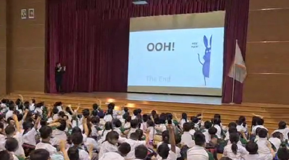 Students interacting with the librarian from National Library Board during a book sharing session