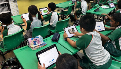 Students using tablets in a classroom for interactive digital learning.